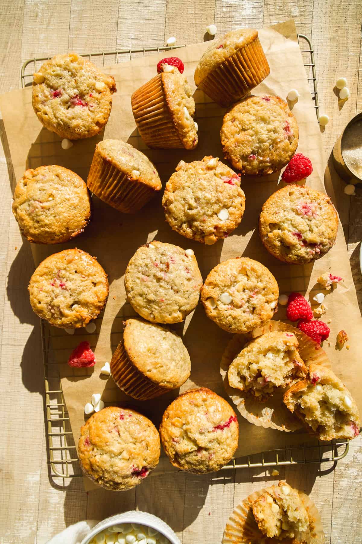 Overhead view of a pile of raspberry white chocolate muffins on a cooling rack.
