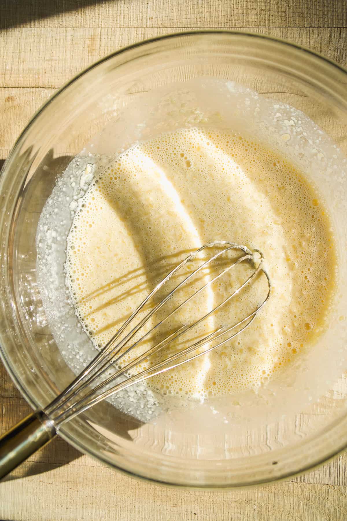 Raspberry white chocolate muffin batter in a glass bowl.