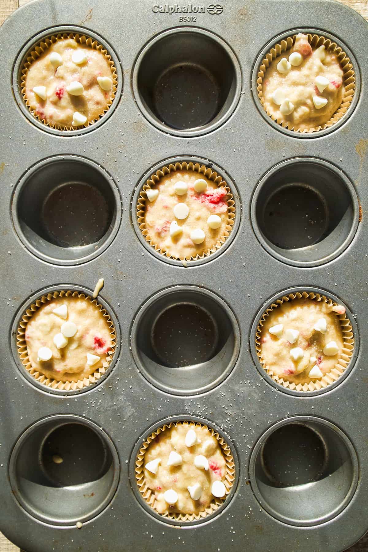 White chocolate raspberry muffins in a pan.