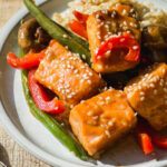 Salmon stir fry with sesame seeds on a plate.