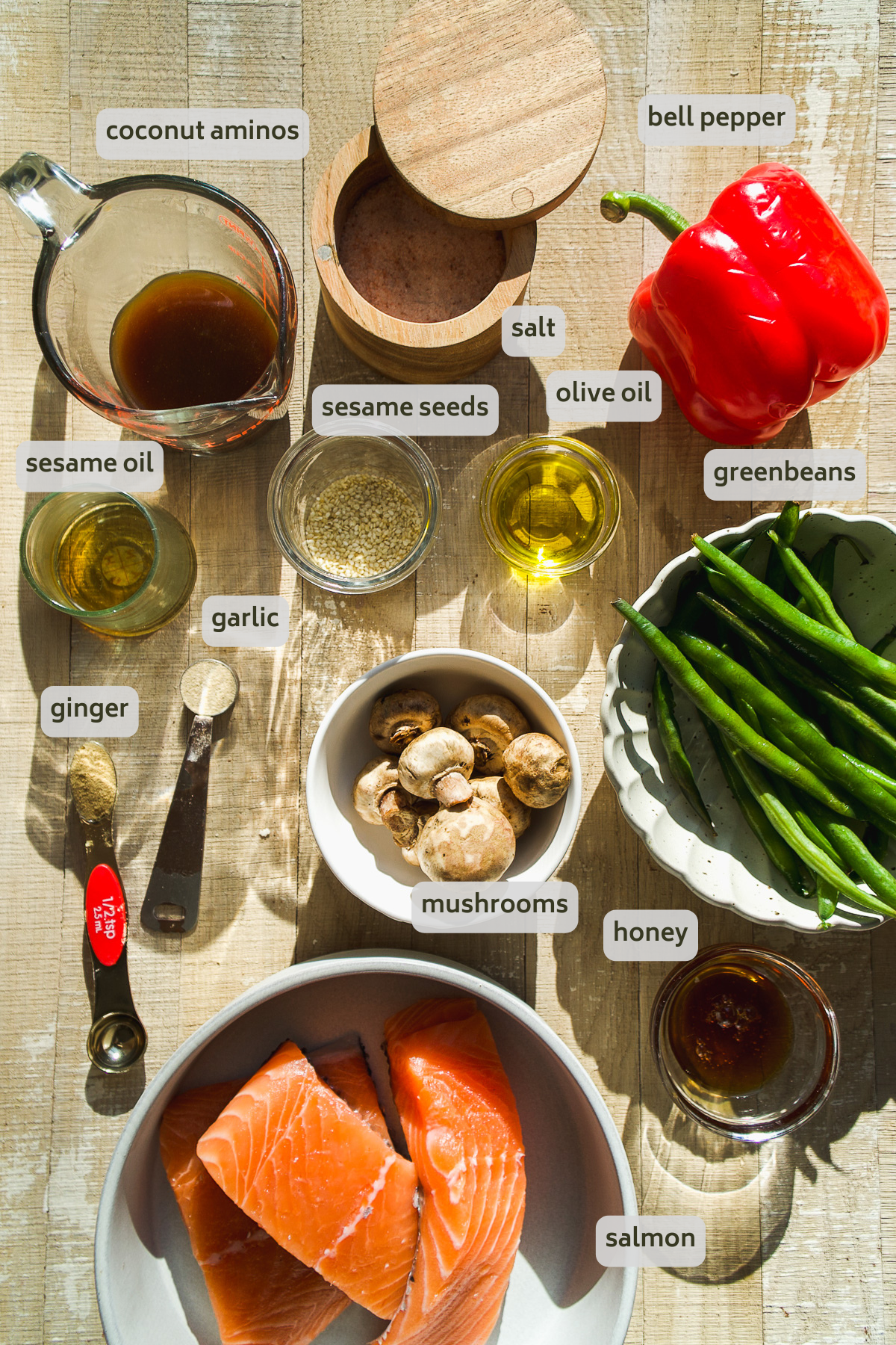 Salmon stir fry ingredients on a light wooden surface.