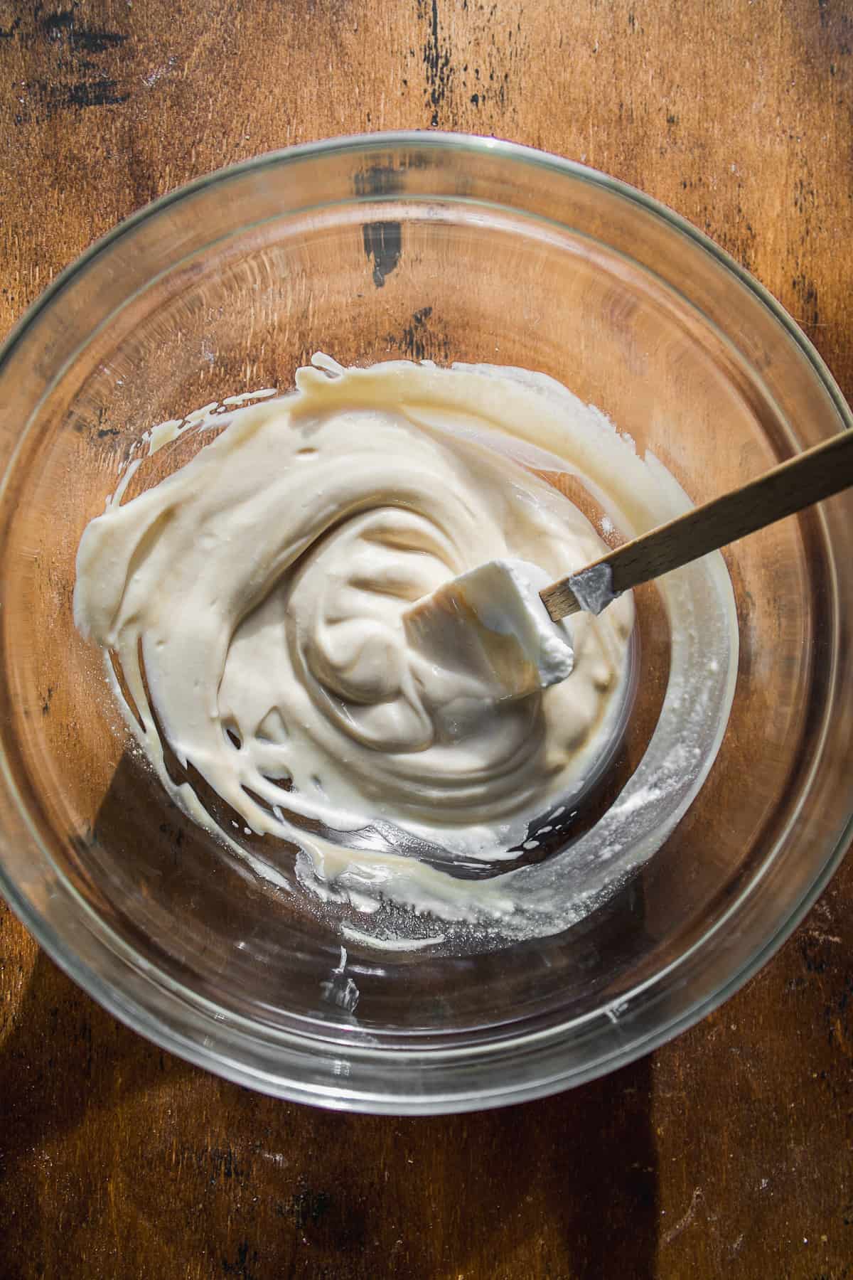 Glass bowl with yogurt mixed inside.