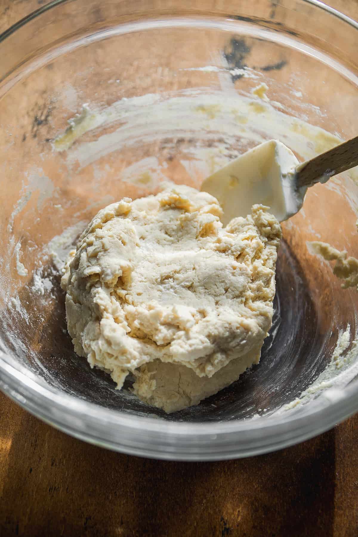 Ball of dough in a glass bowl.