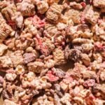 Valentine snack mix with white chocolate and strawberries on parchment paper.