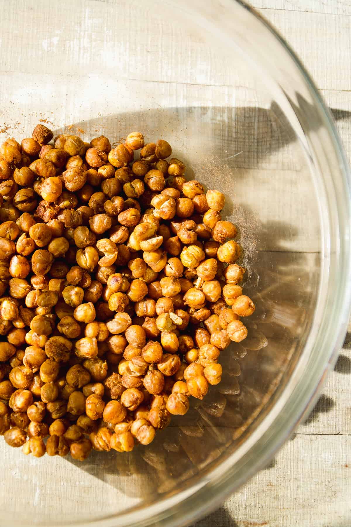 Glass bowl with roasted chickpeas in cinnamon sugar.