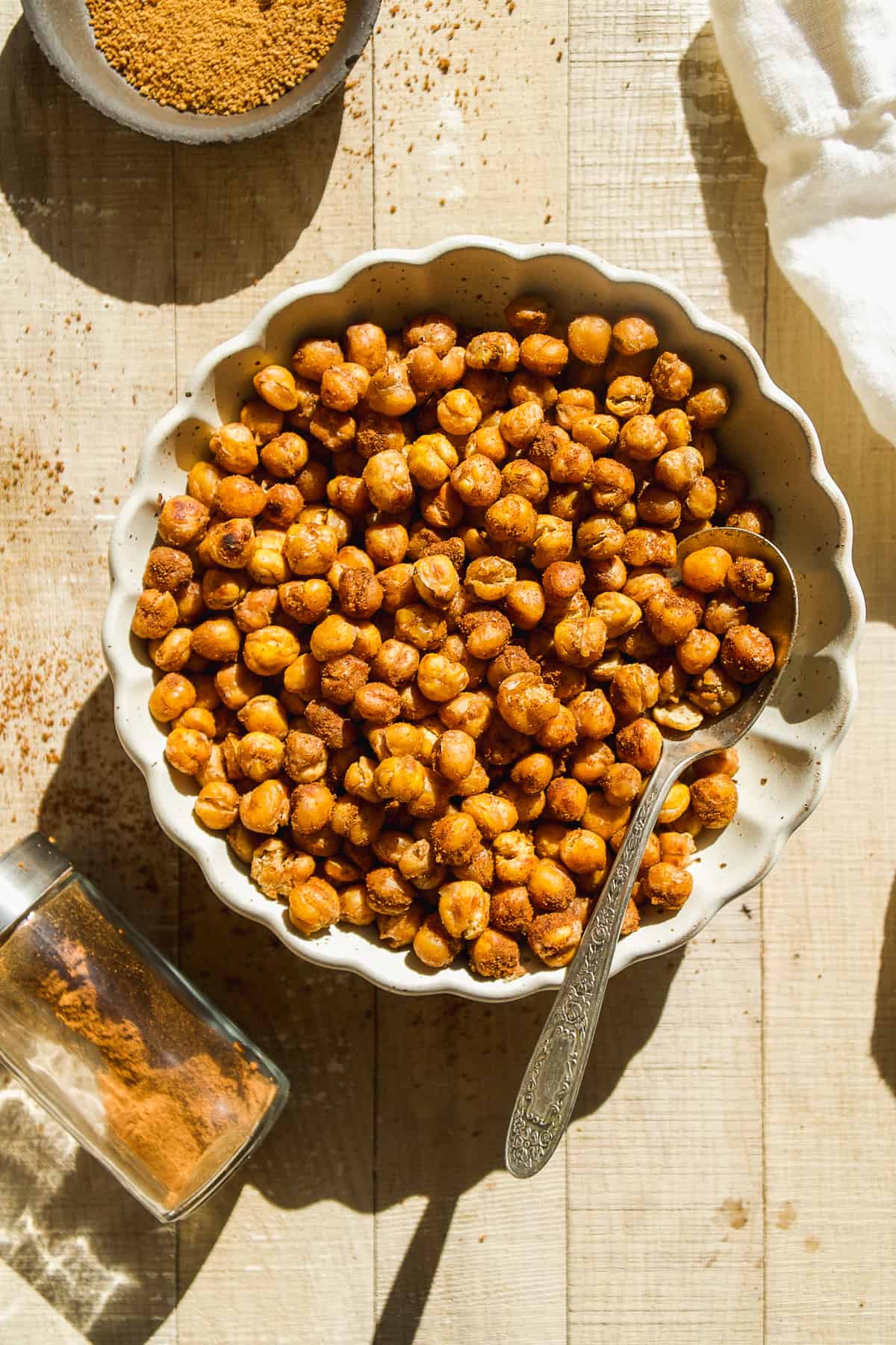 Cinnamon sugar roasted chickpeas in a bowl with cinnamon dusted on the surface.