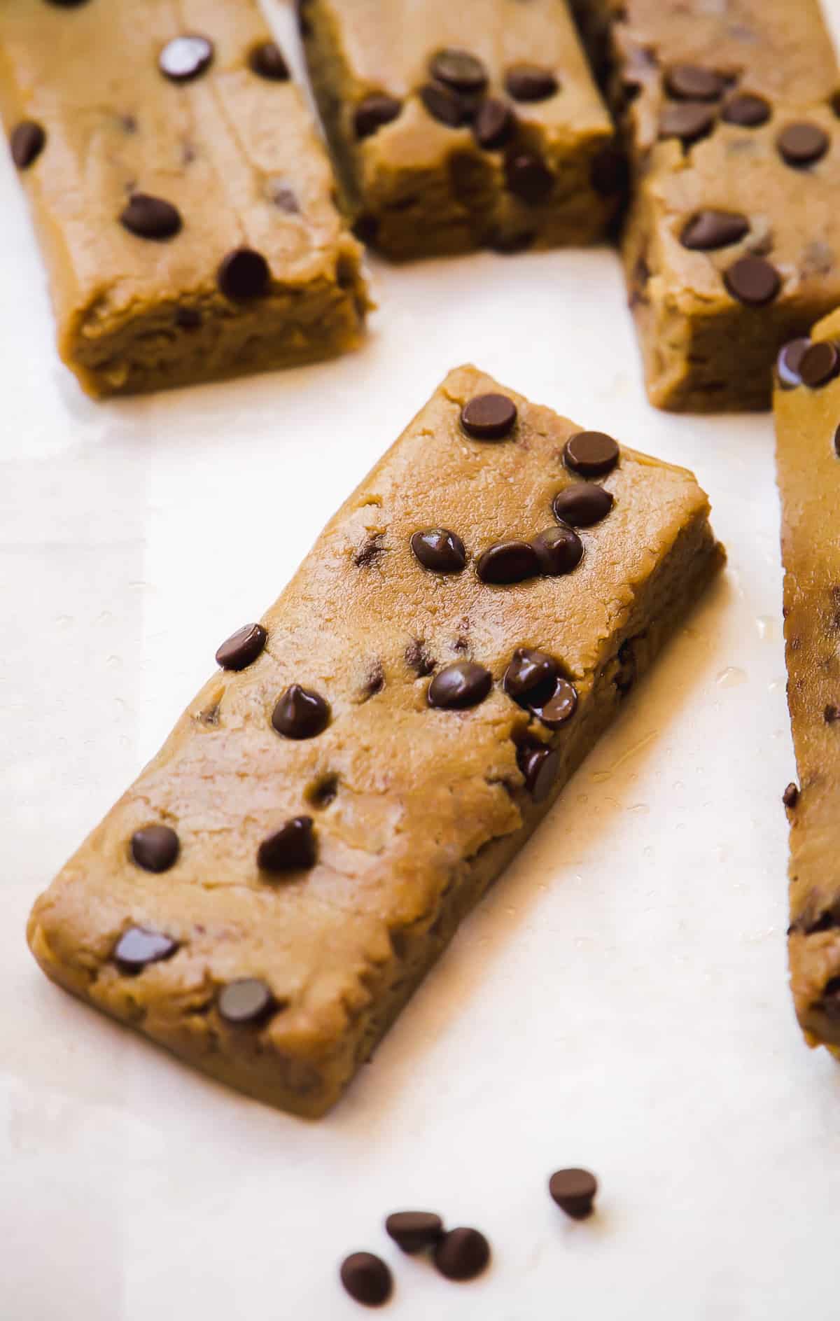 Cookie dough protein bar with chocolate chips on a piece of parchment paper.