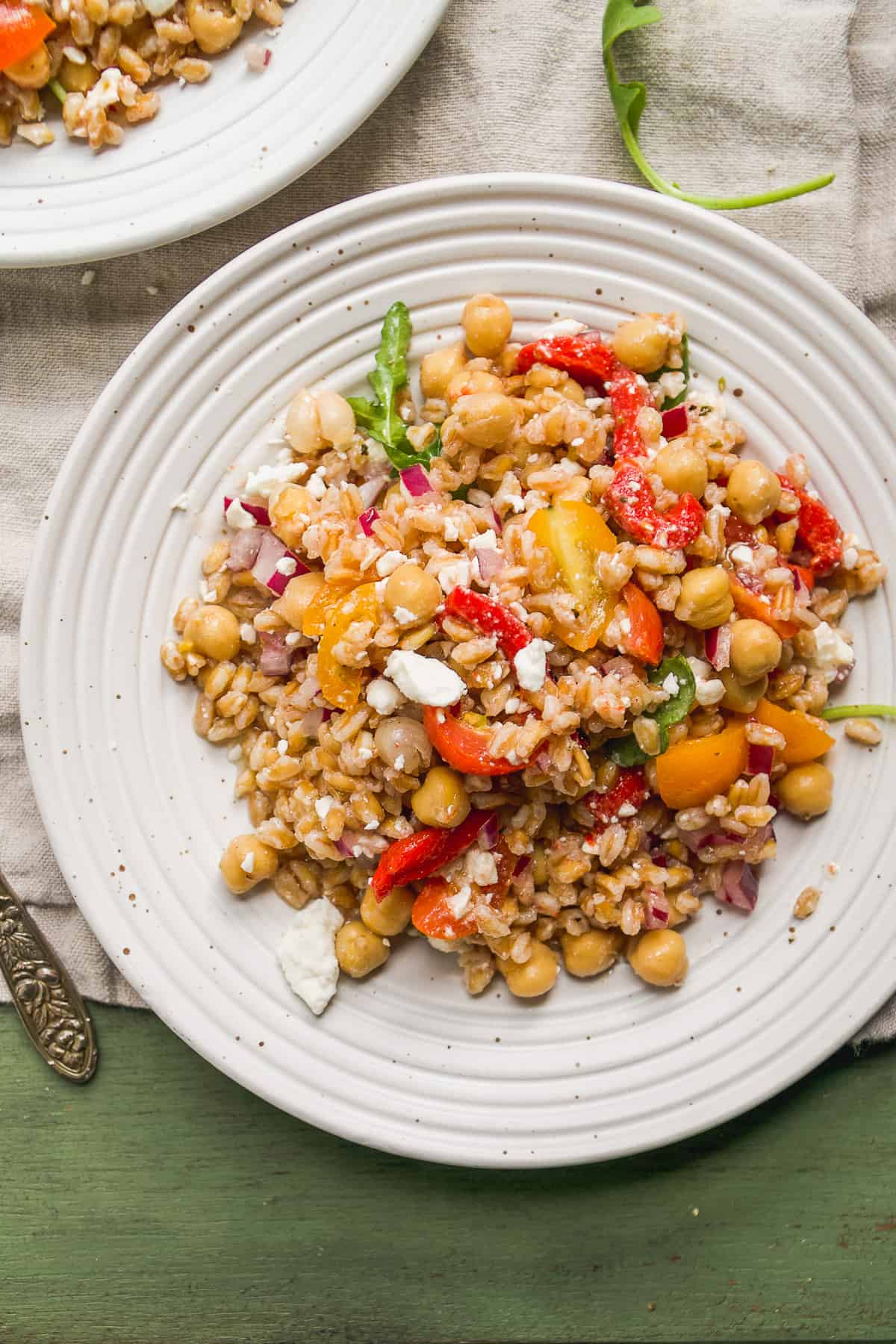 Overhead view of farro salad on a plate on a green surface.