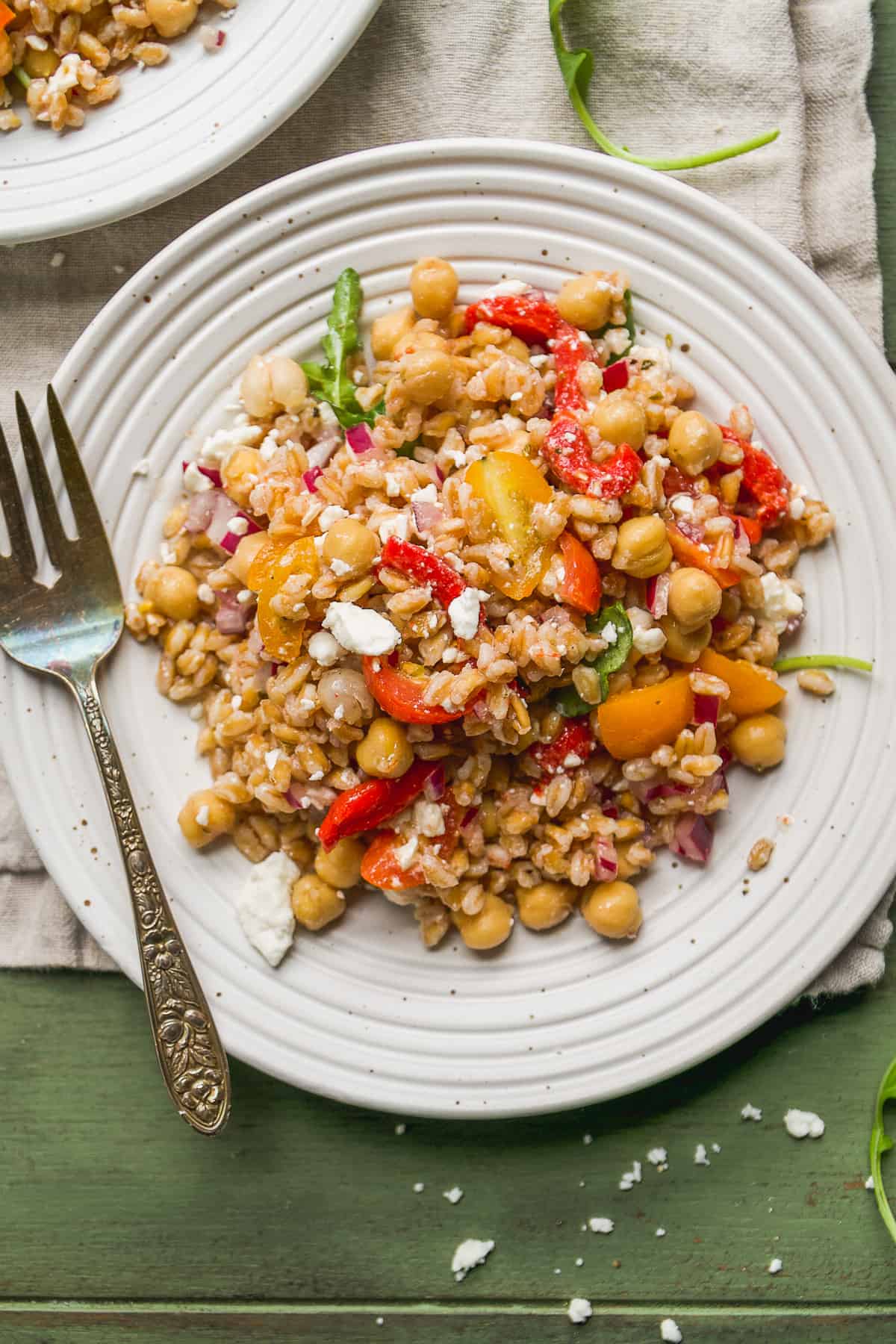 Mediterranean farro salad on a white plate with a fork.