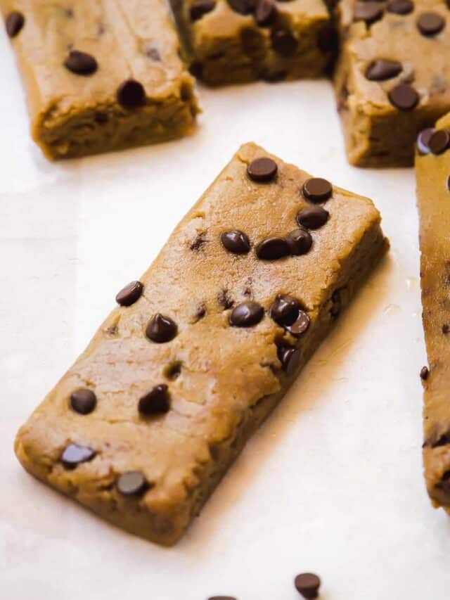 Cookie dough protein bar with chocolate chips on a piece of parchment paper.