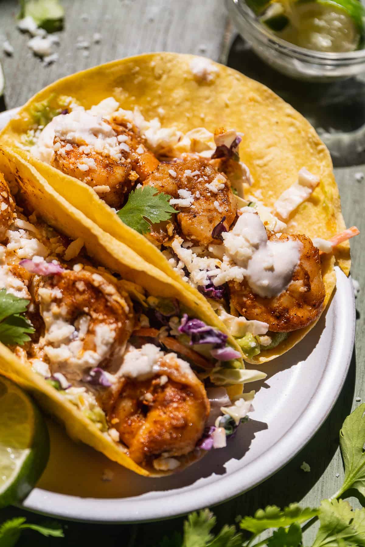 Baja shrimp tacos in yellow tortillas with sauce.