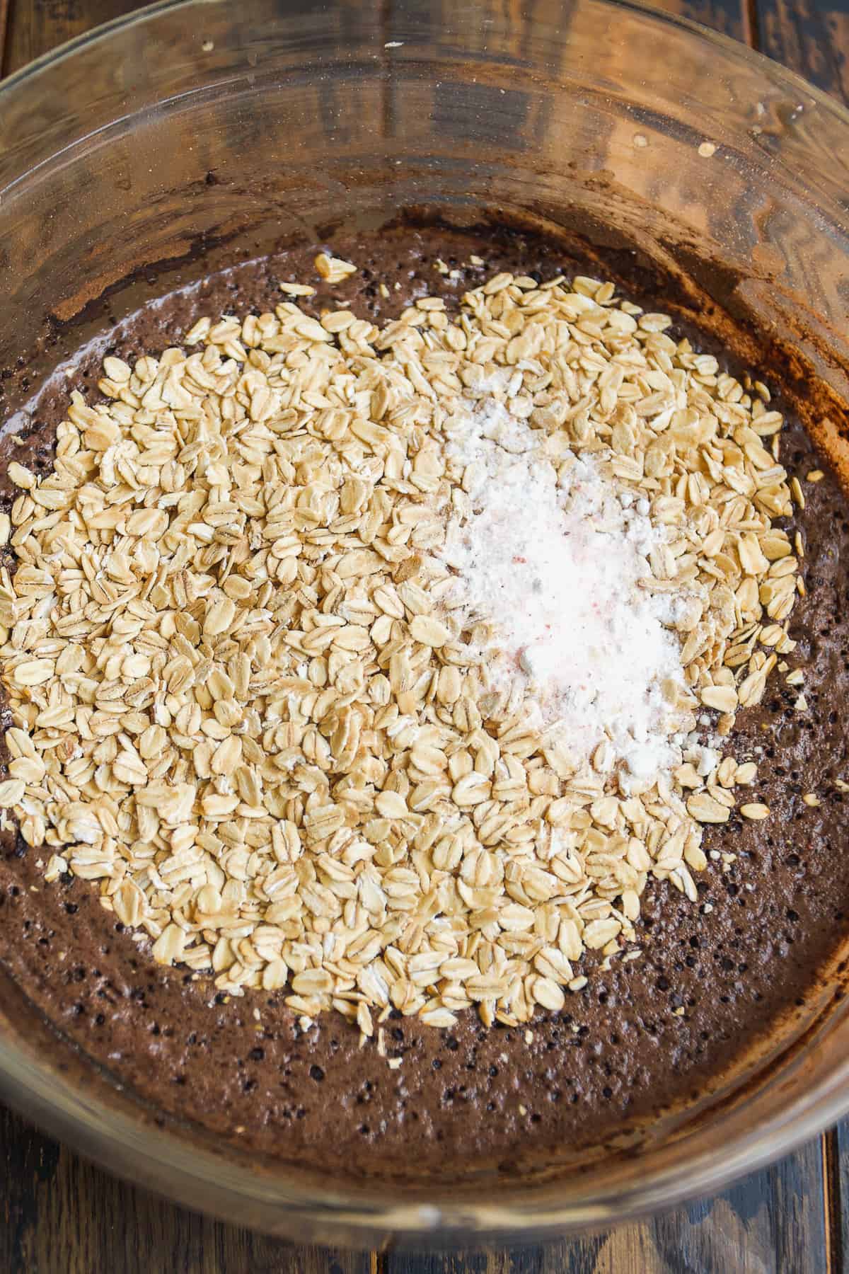 Chocolate baked oats in a glass bowl about to be mixed.