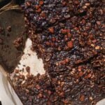 Brownie baked oats in a white container with chocolate chips.