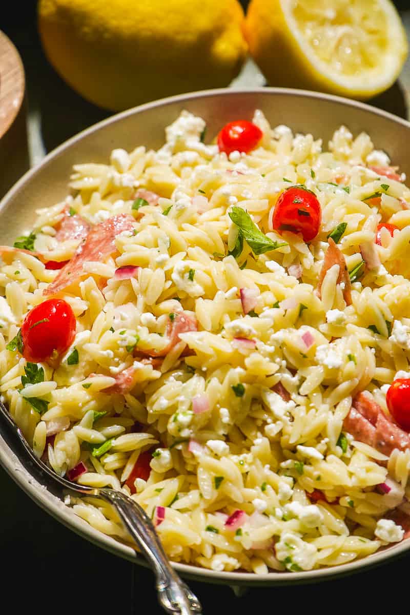 Summer lemon orzo salad with tomatoes in a large dish.