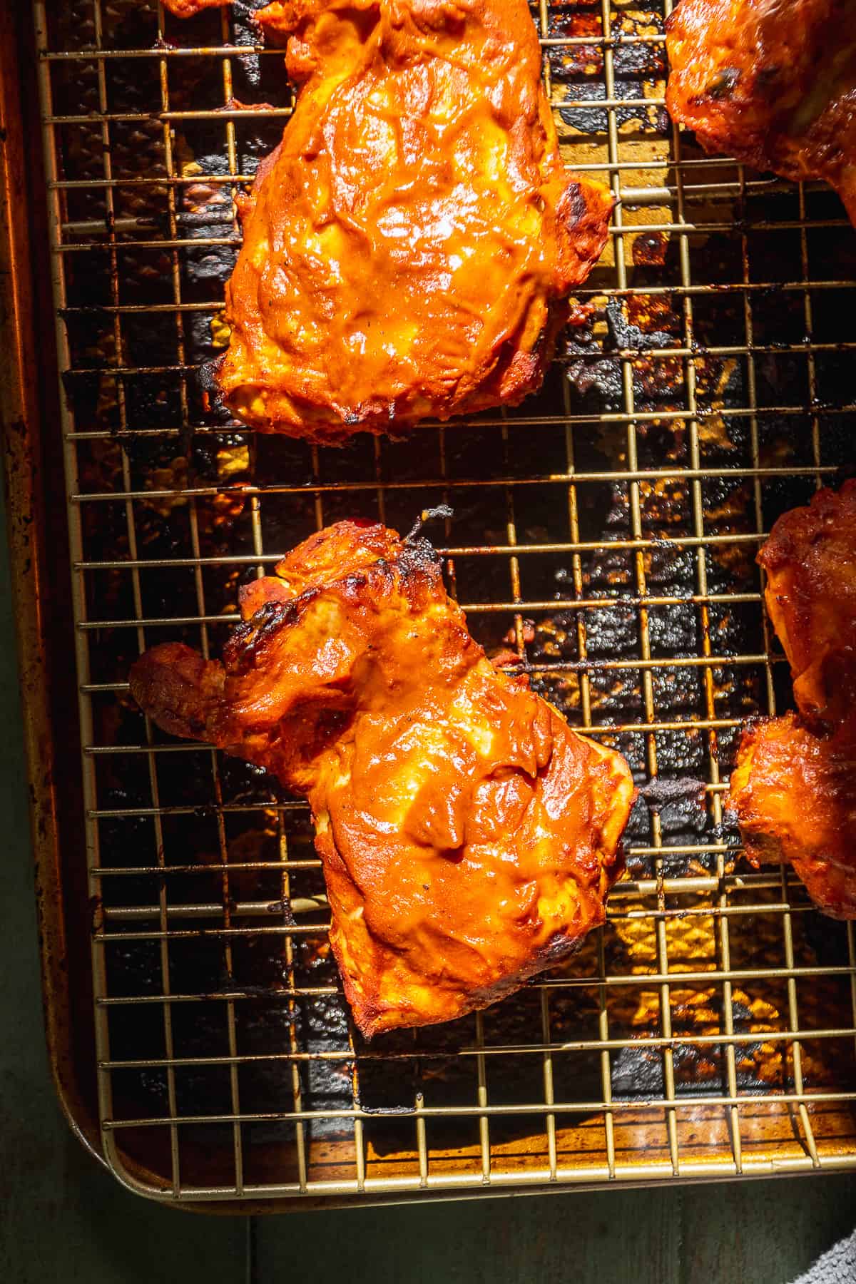 Baked bbq chicken thighs on a baking sheet.