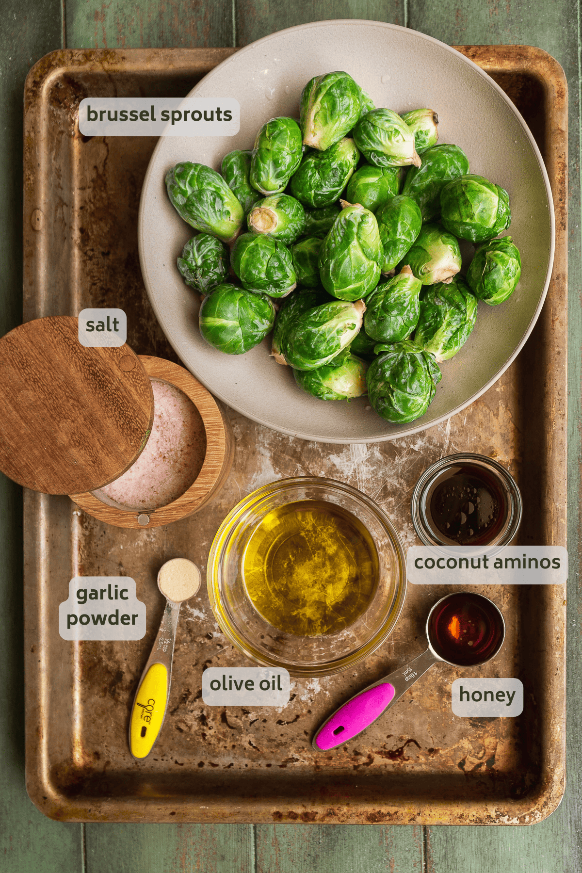 Caramelized brussel sprouts ingredients on a silver baking sheet.