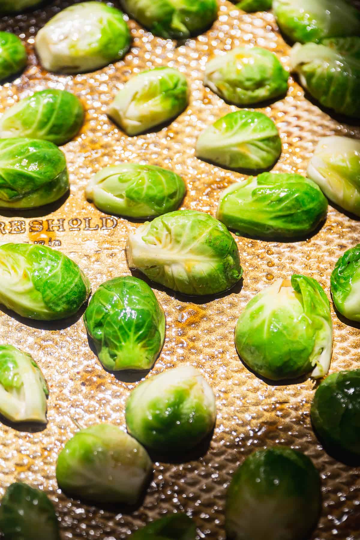 Brussel sprouts cut into halves on a baking sheet.