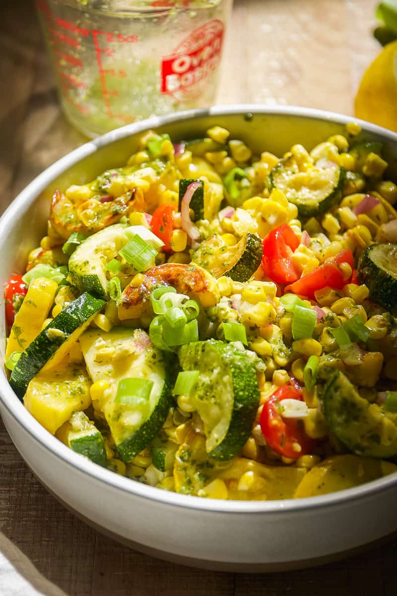 Grilled vegetable salad in a circular dish with corn and zucchini.