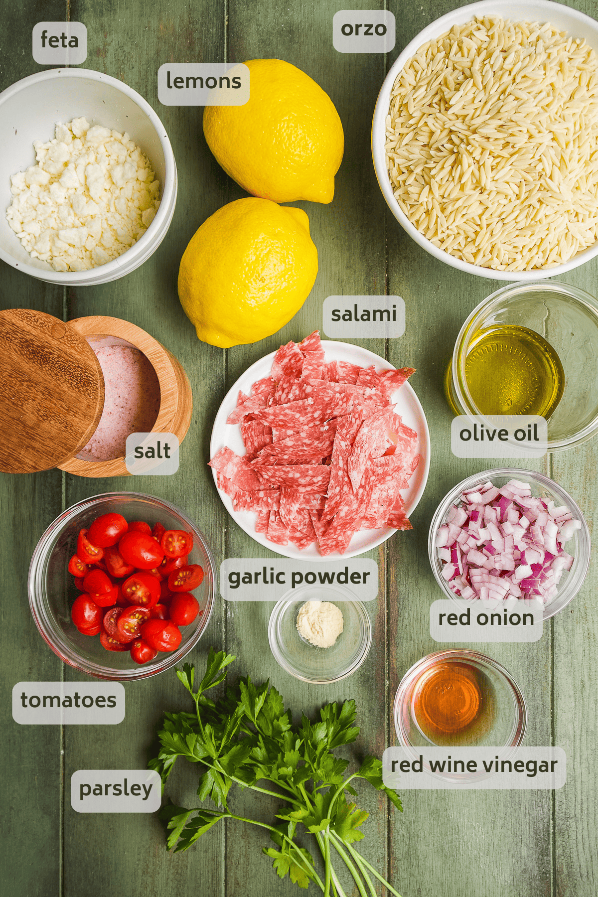 Lemon orzo pasta ingredients on a green surface.