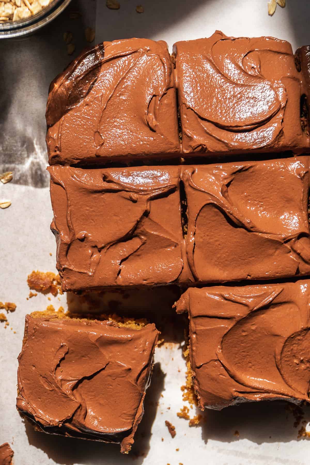 Square oat flour cake with thick chocolate icing.