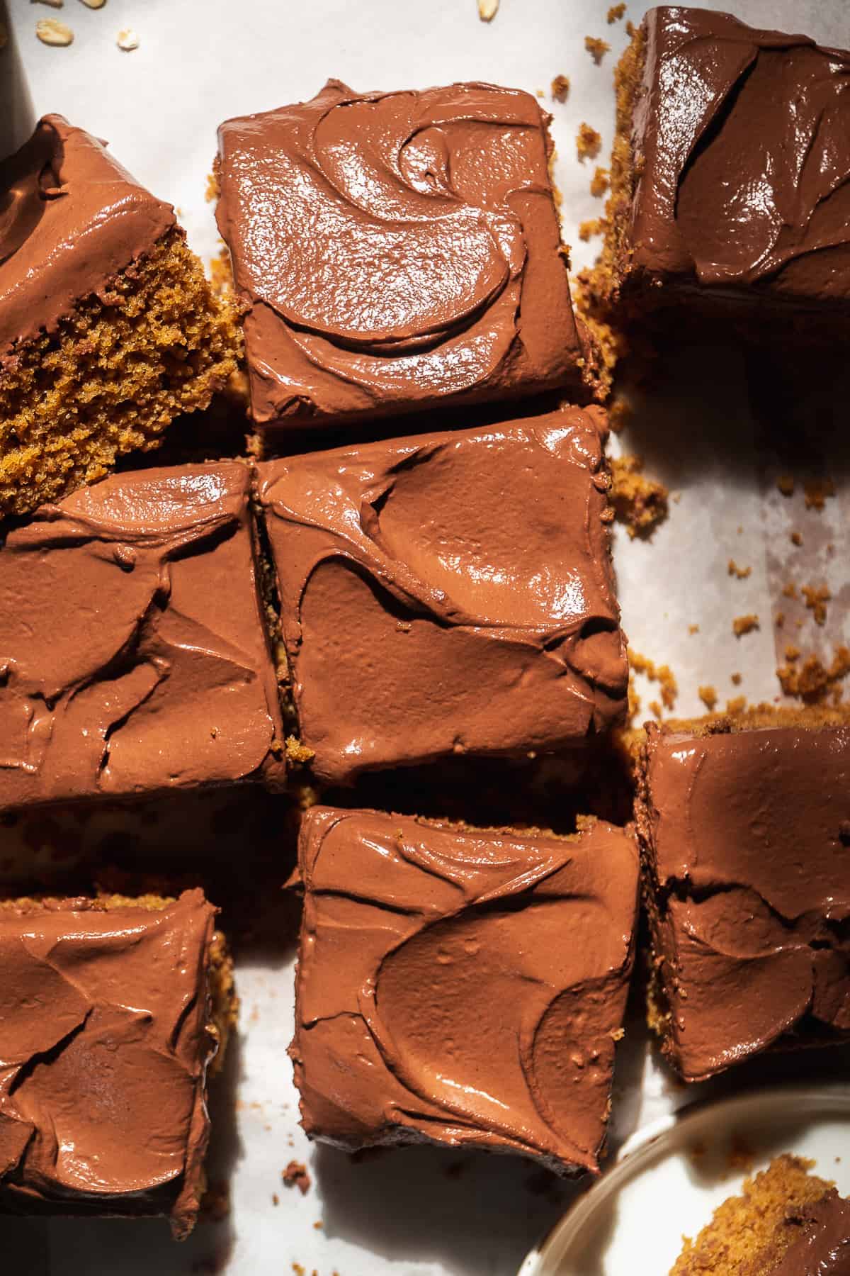 Chocolate oat flour cake cut into slices on parchment paper.