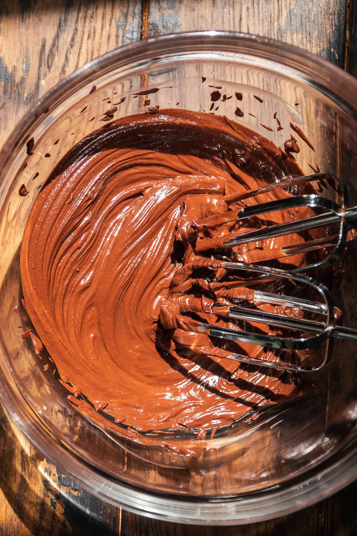 Chocolate greek yogurt icing mixed in a glass bowl.