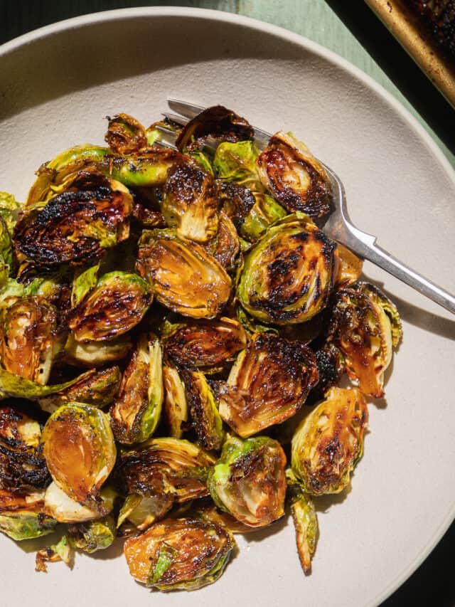 Toasted caramelized brussel sprouts in a bowl with a fork.
