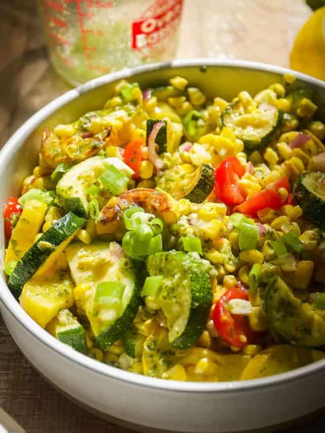 Grilled vegetable salad in a circular dish with corn and zucchini.