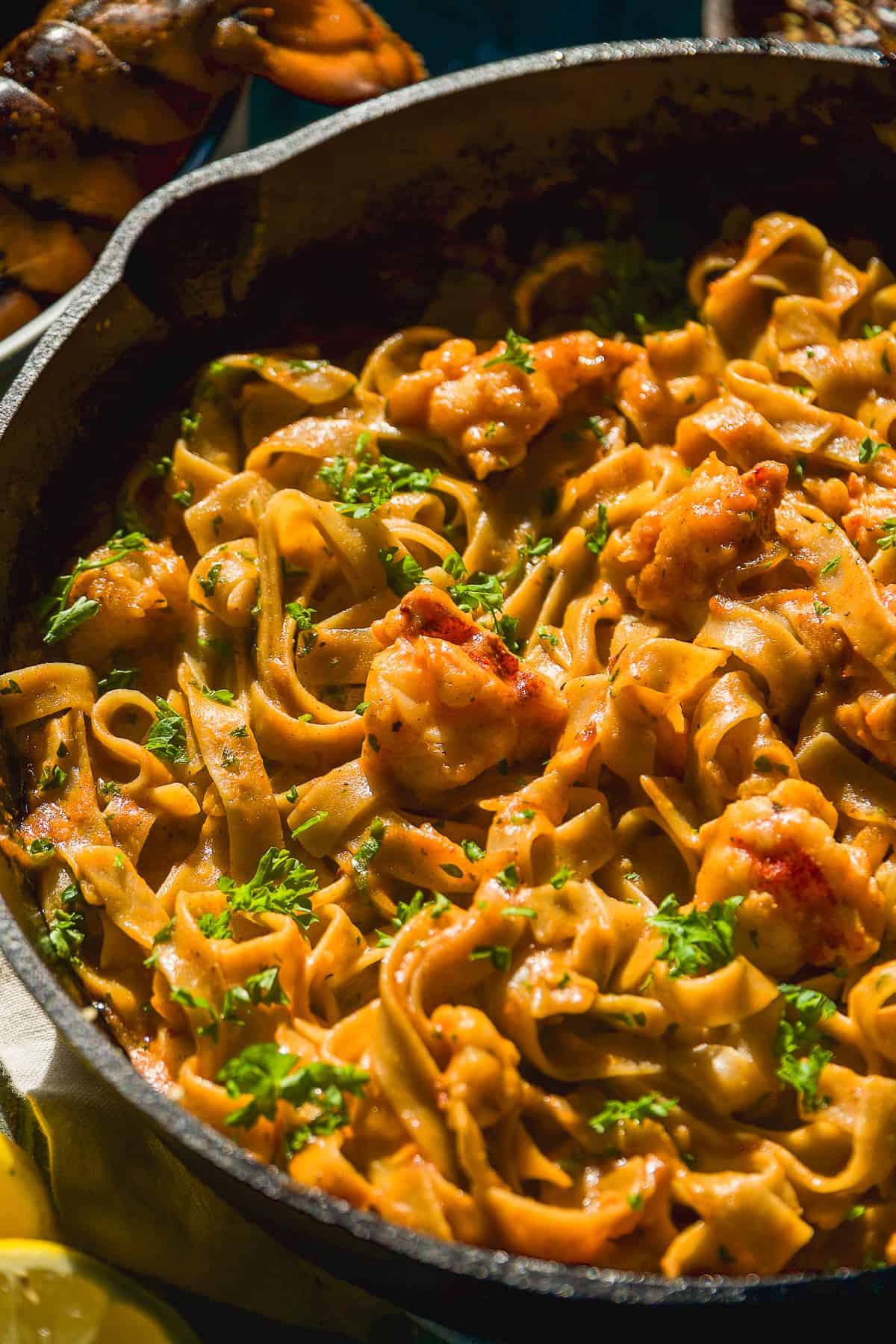 Cajun pasta with lobster meat in a cast iron skillet.