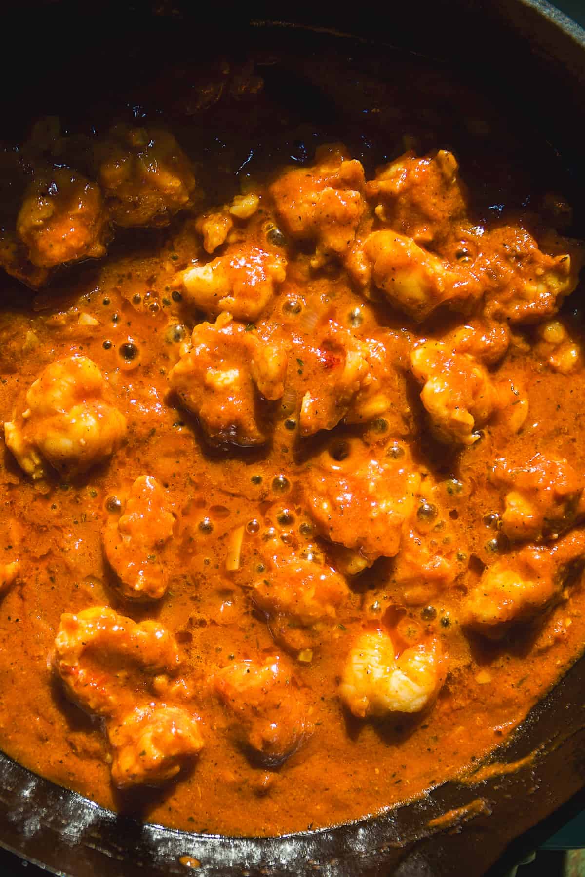 Lobster tail meat simmering in cajun pasta sauce.