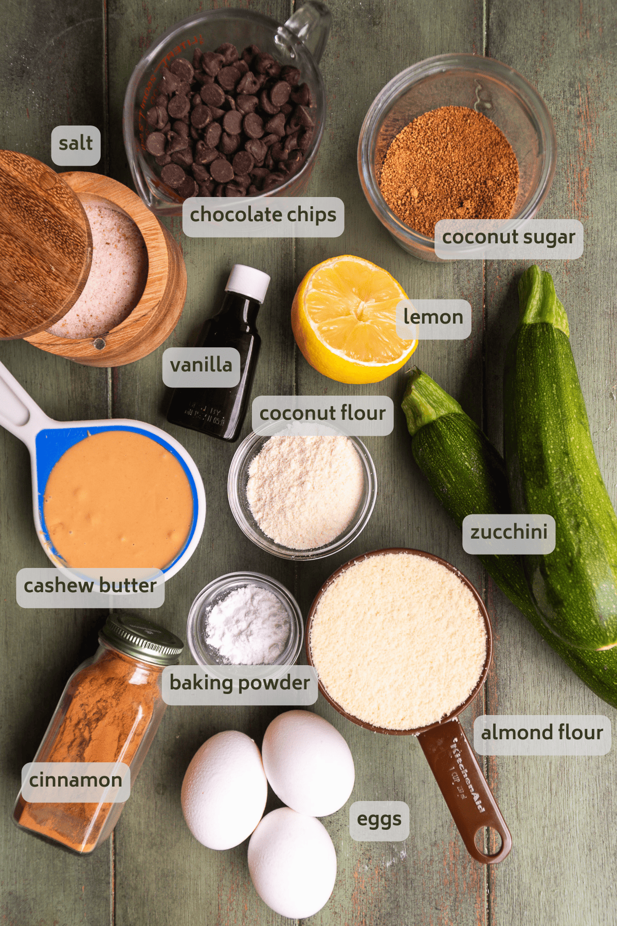 Gluten free zucchini bread ingredients on a green backdrop.