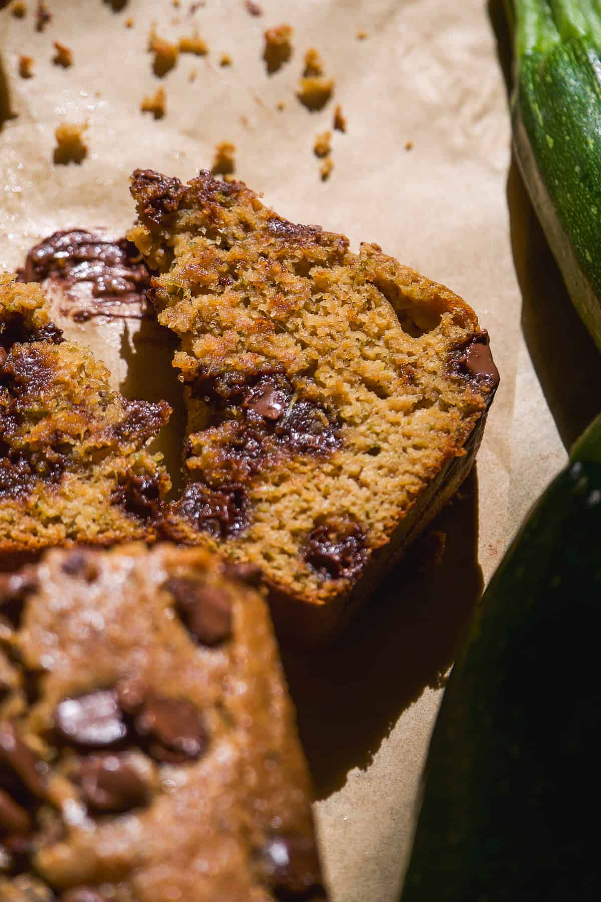 Slice of chocolate chip zucchini bread on parchment paper.