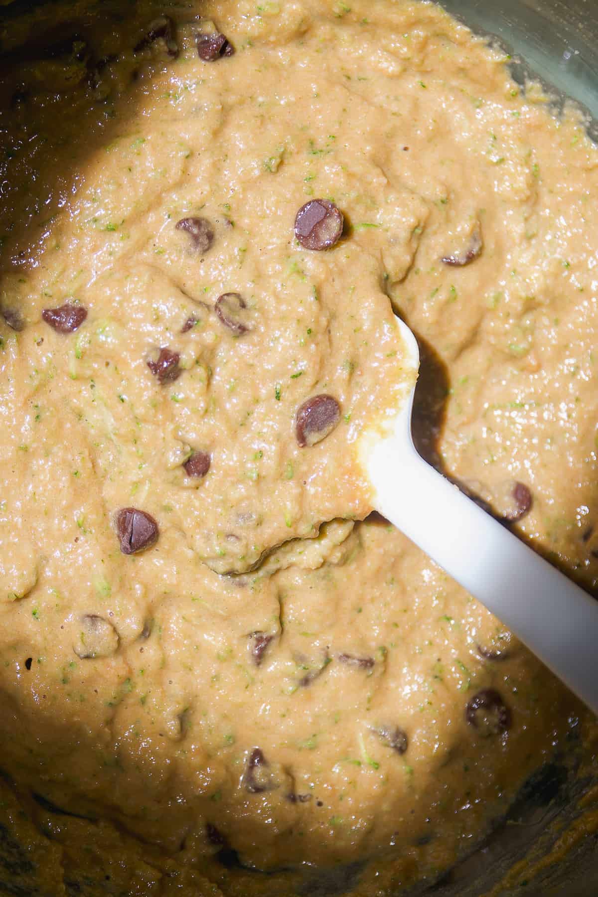 Chocolate chip zucchini bread batter mixed in a large glass bowl.