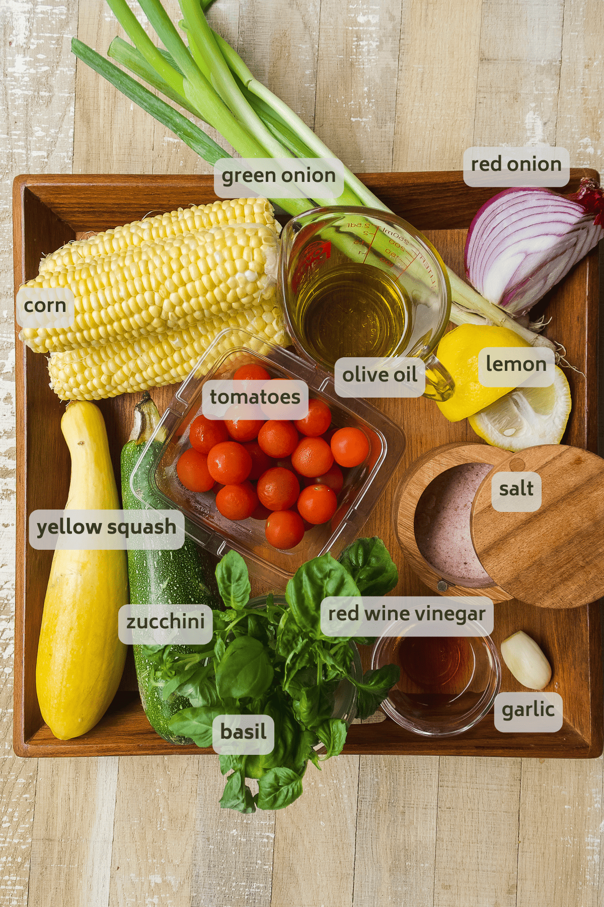 Grilled vegetable salad ingredients on a wooden platter.