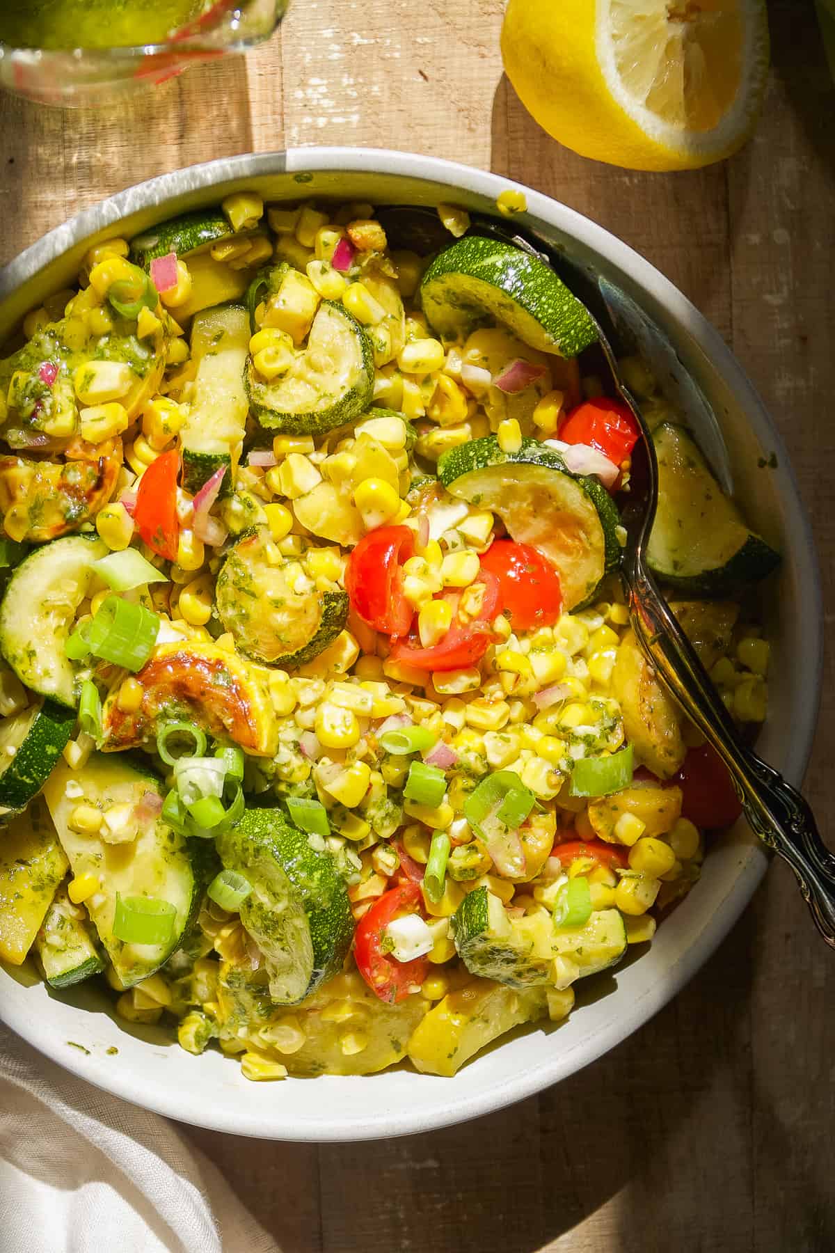 Grilled vegetable salad in a circular dish with corn and zucchini.