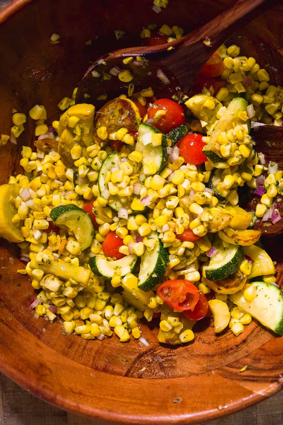 Grilled vegetables tossed in a wooden bowl.