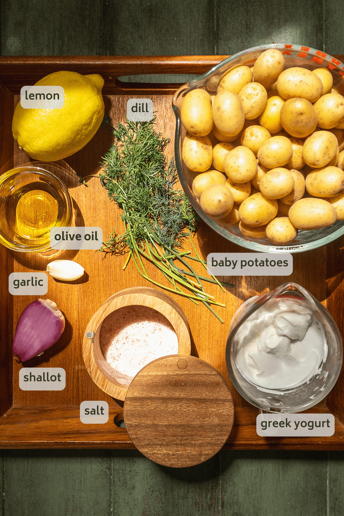 Healthy potato salad ingredients on a wooden platter.