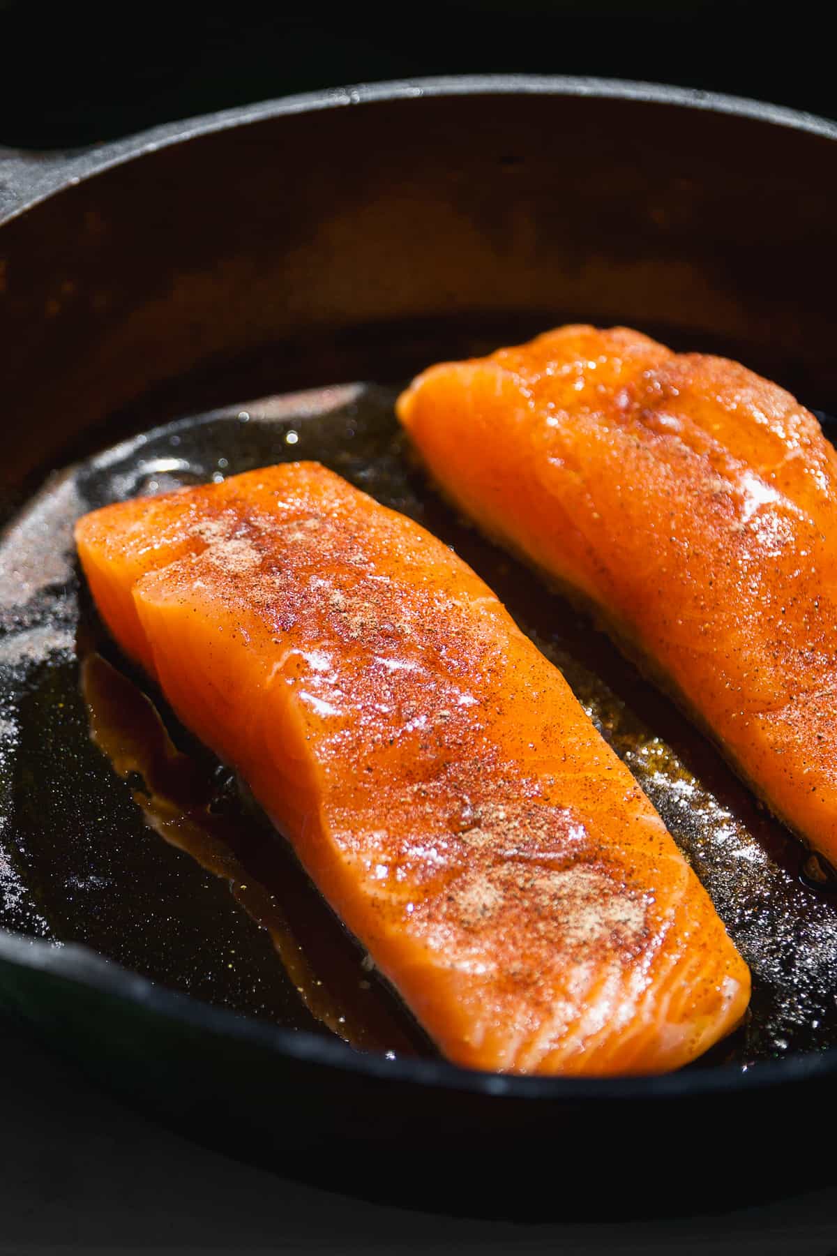 Salmon cooking in a cast iron skillet.