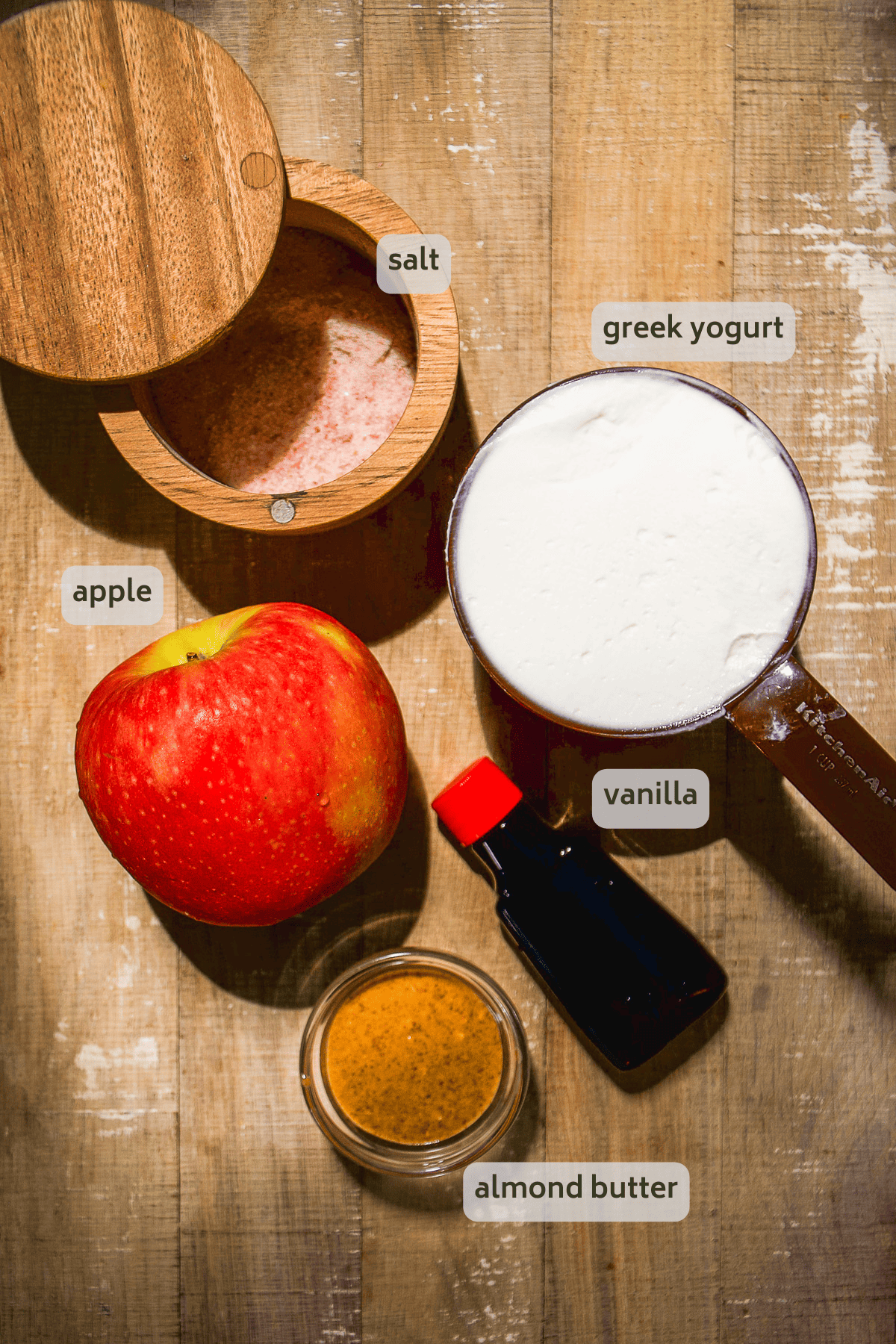 Yogurt fruit dip ingredients on a wooden surface with labels.