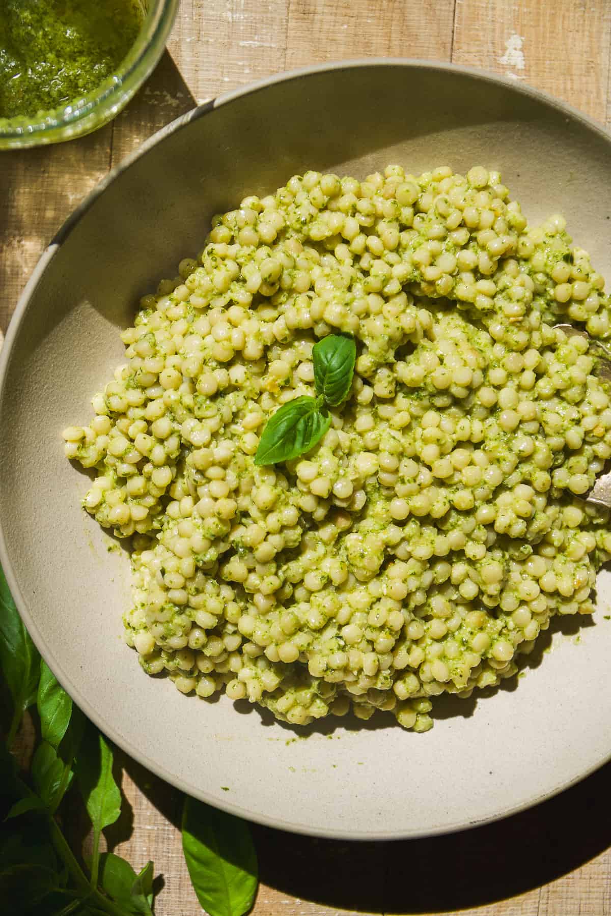 Pesto couscous in a bowl with basil.