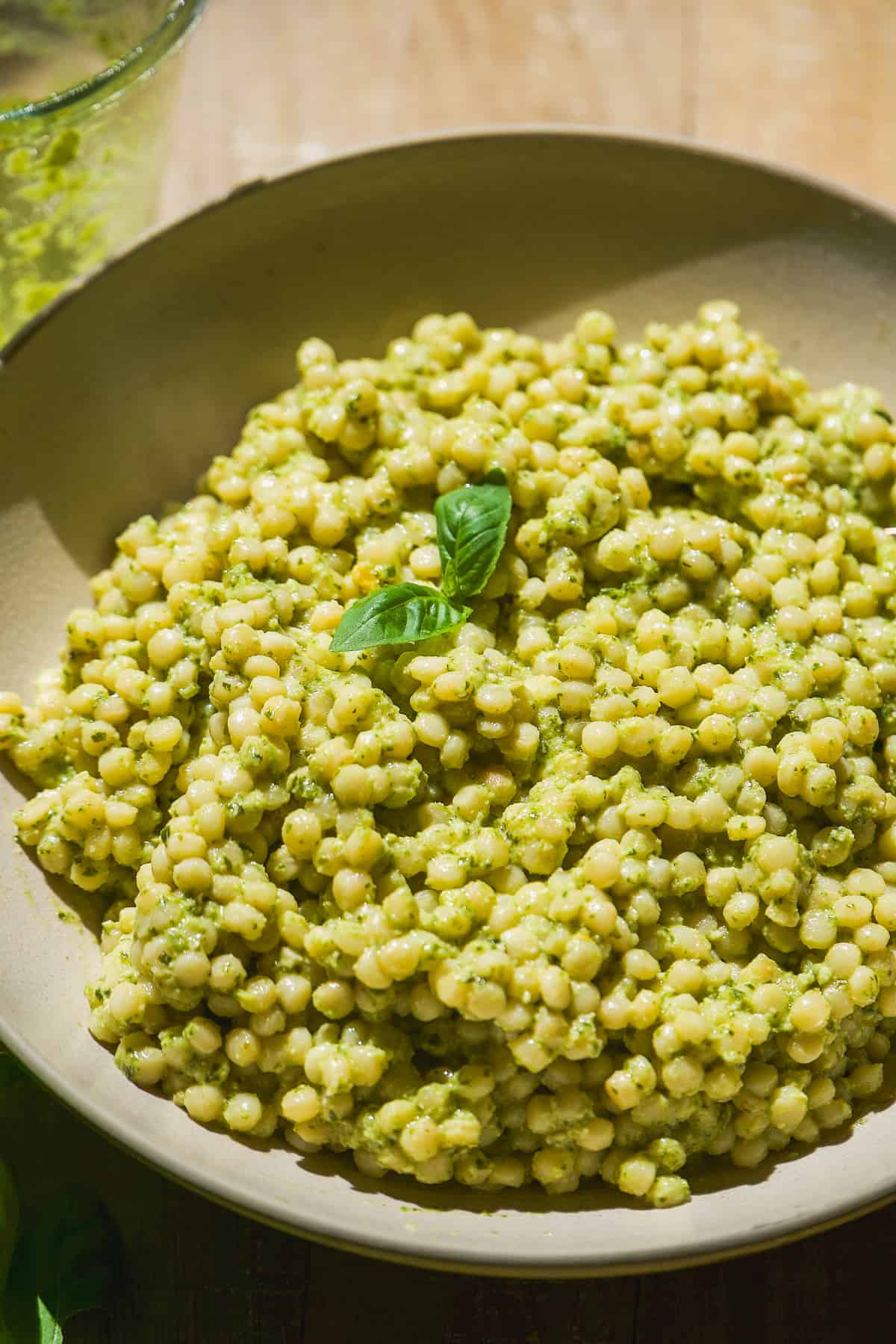 Up close view of a bowl with pesto couscous.