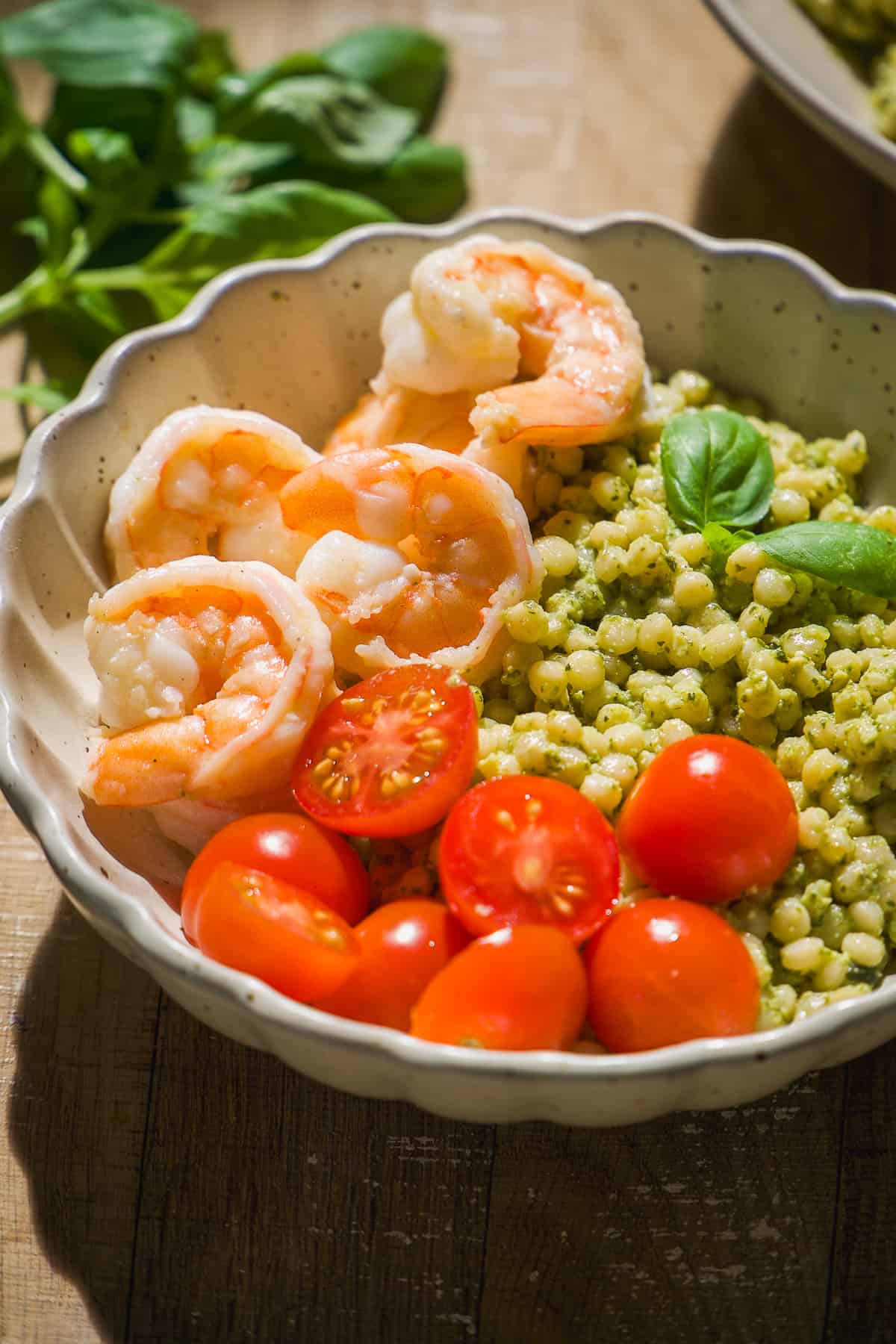 Shrimp bowls with pesto couscous and basil.