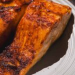 Air fried filets of honey garlic salmon on a plate.
