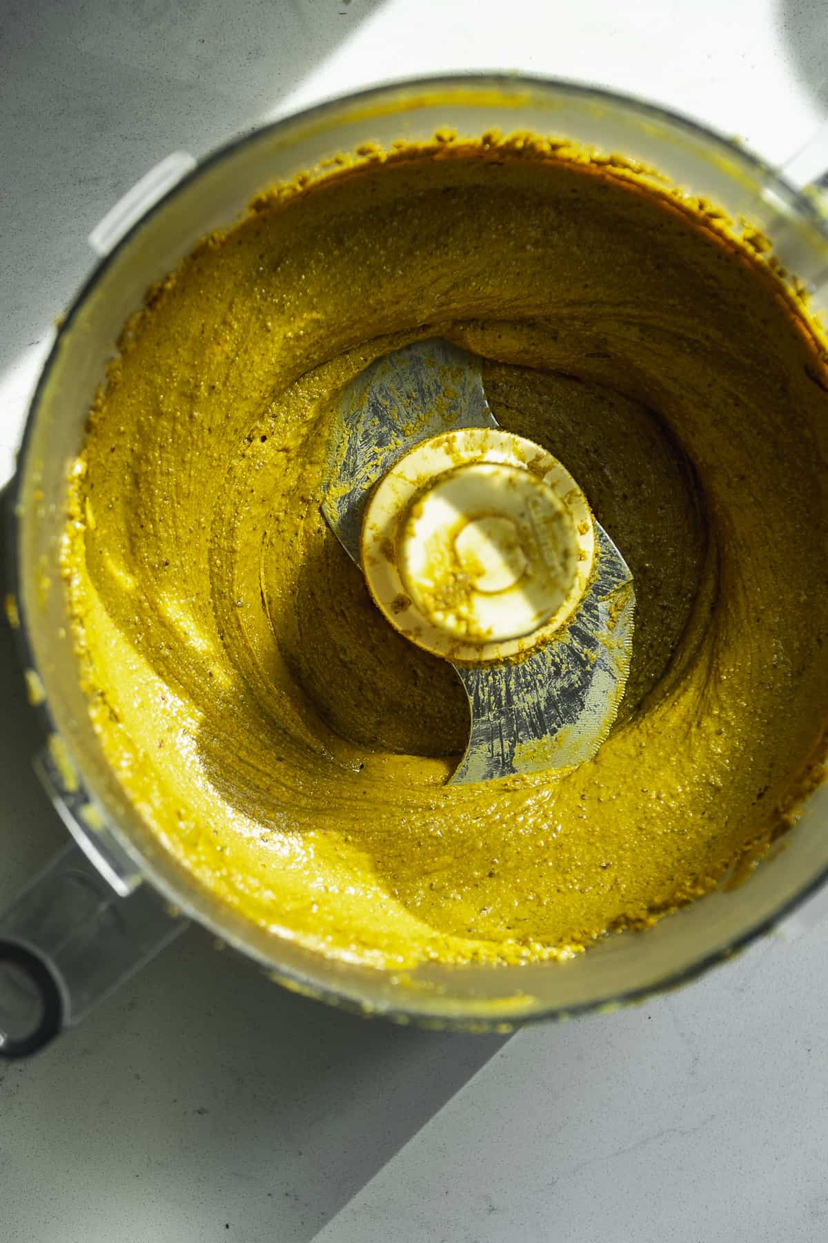 Overhead view of a food processor with pistachio butter.