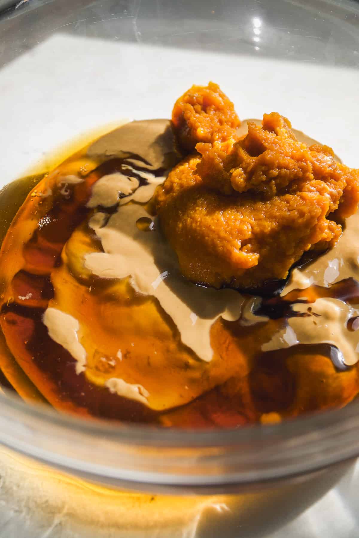 Pumpkin puree mixed with sunflower butter and maple syrup in a large bowl.