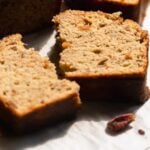 Sugar free banana bread slice on a white surface.