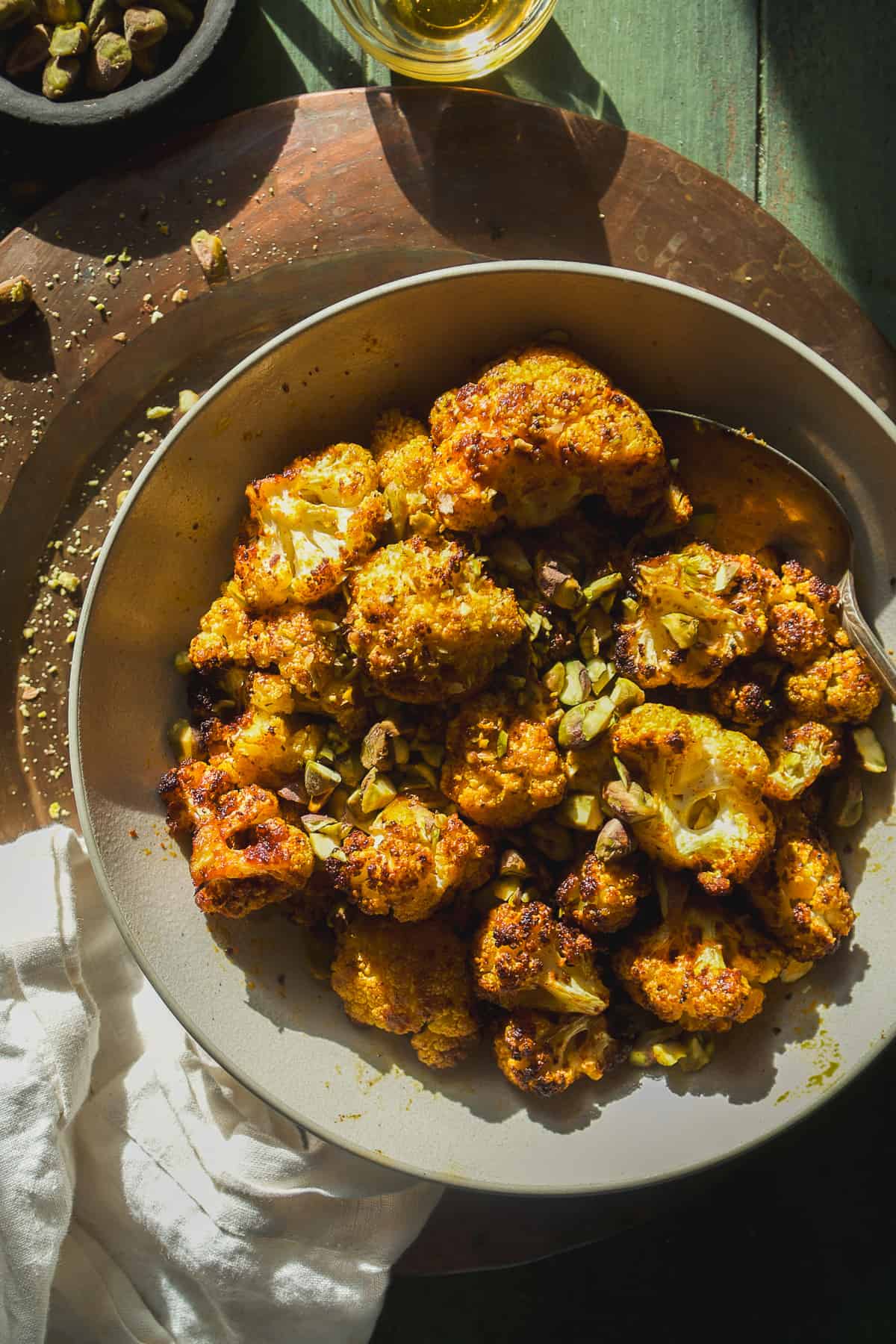 Air fried cauliflower bites with honey and pistachios in a bowl.
