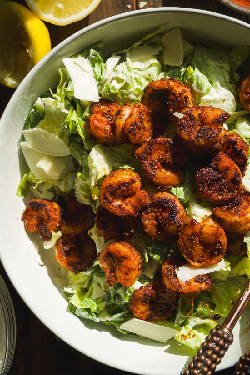 Blackened shrimp on top of caesar salad.