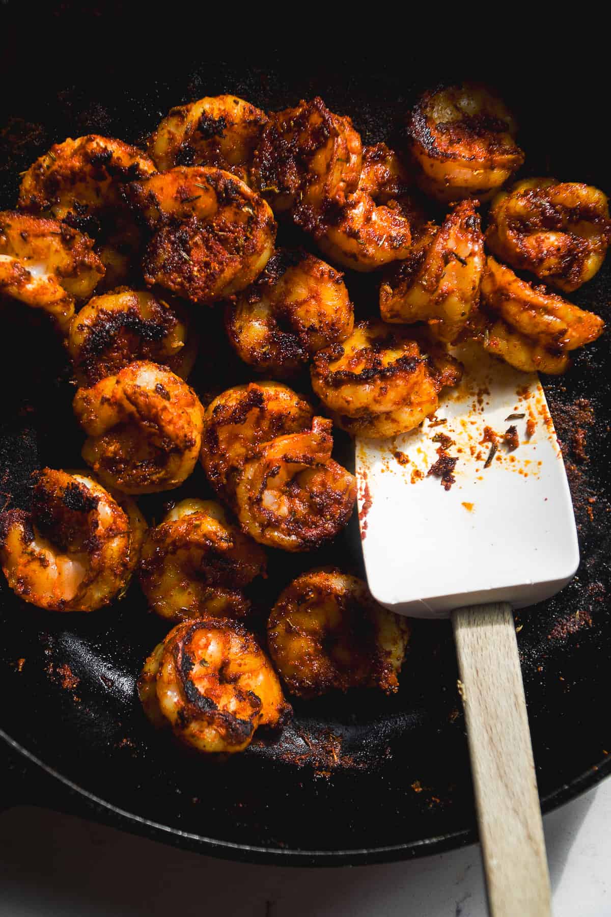 Blackened shrimp cooked in a cast iron skillet.