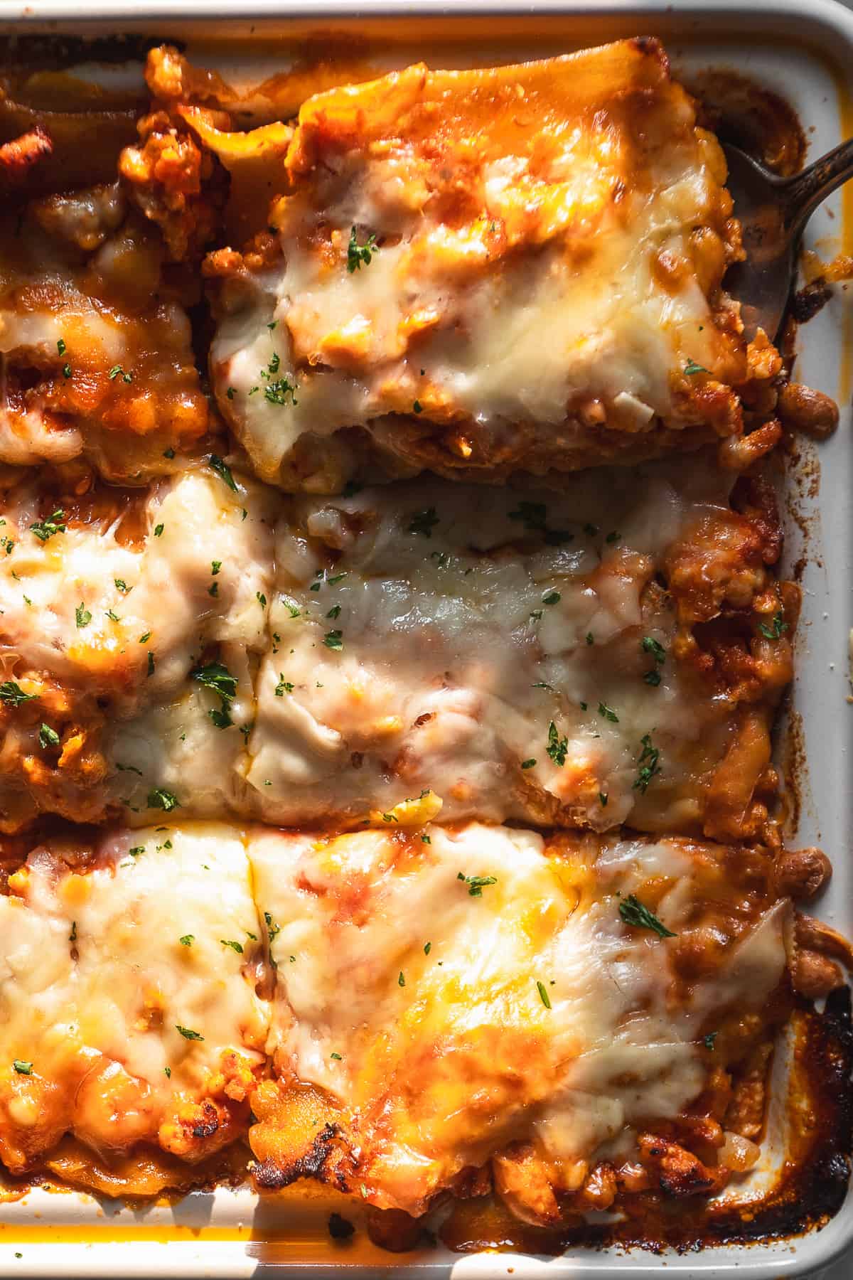 Turkey lasagna cut into slices in a baking dish.